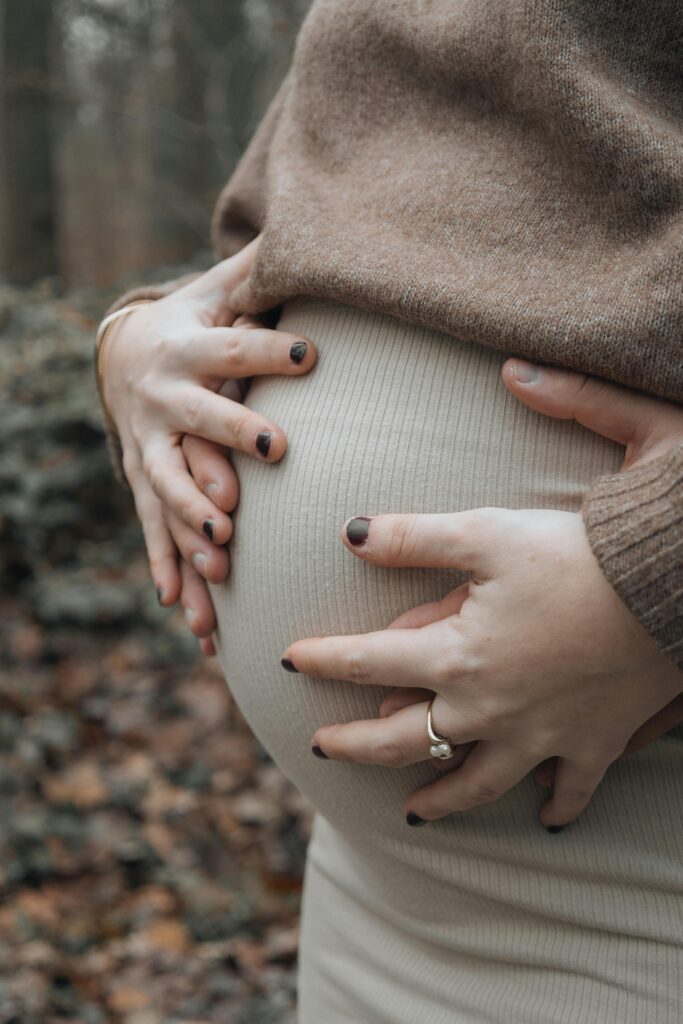 pexels photo 19785740 19785740 Expectant couple gently holding the pregnant belly in a serene outdoor setting.